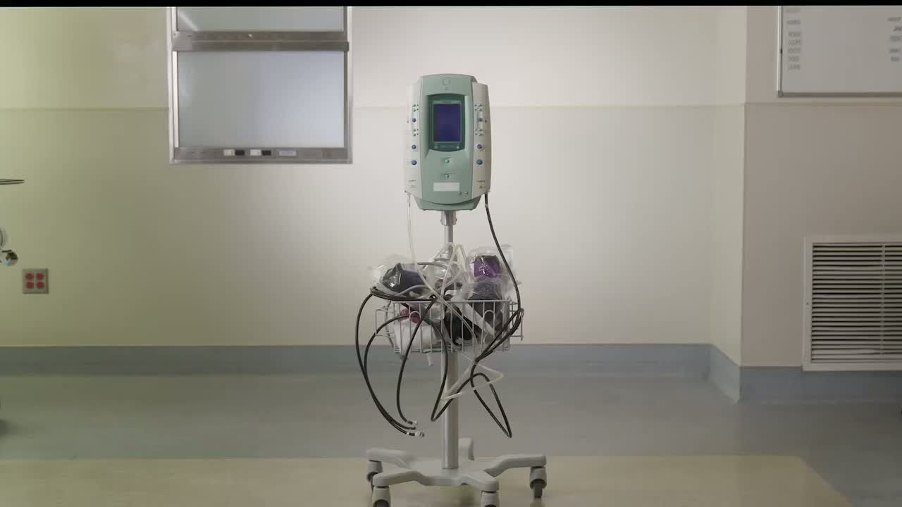 Legacy setup: a standing tourniquet unit with cords and tubing running across the room